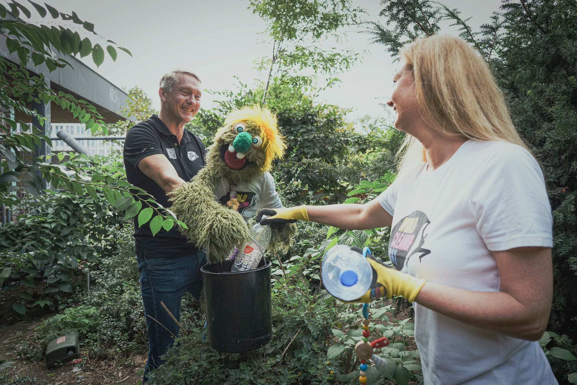 Olfi collecting plastic bottles in a bucket during a cleanup