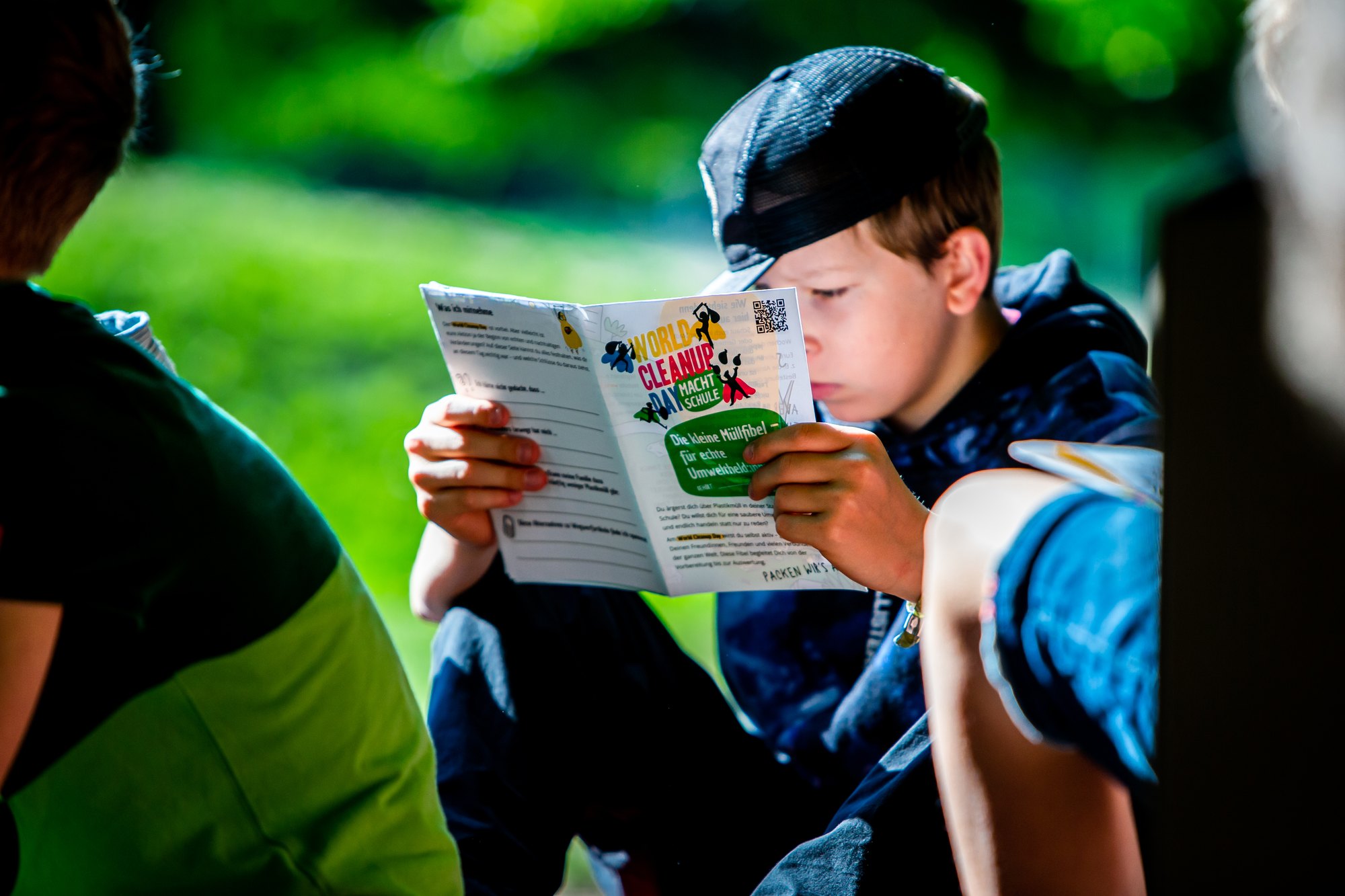 A pupil reading the World Cleanup Day macht Schule waste primer