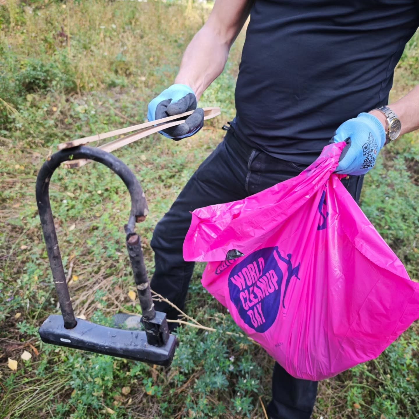 A volunteer collecting a discarded bicycle lock
